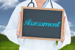 The word assessment and doctor showing chalkboard against field and sky